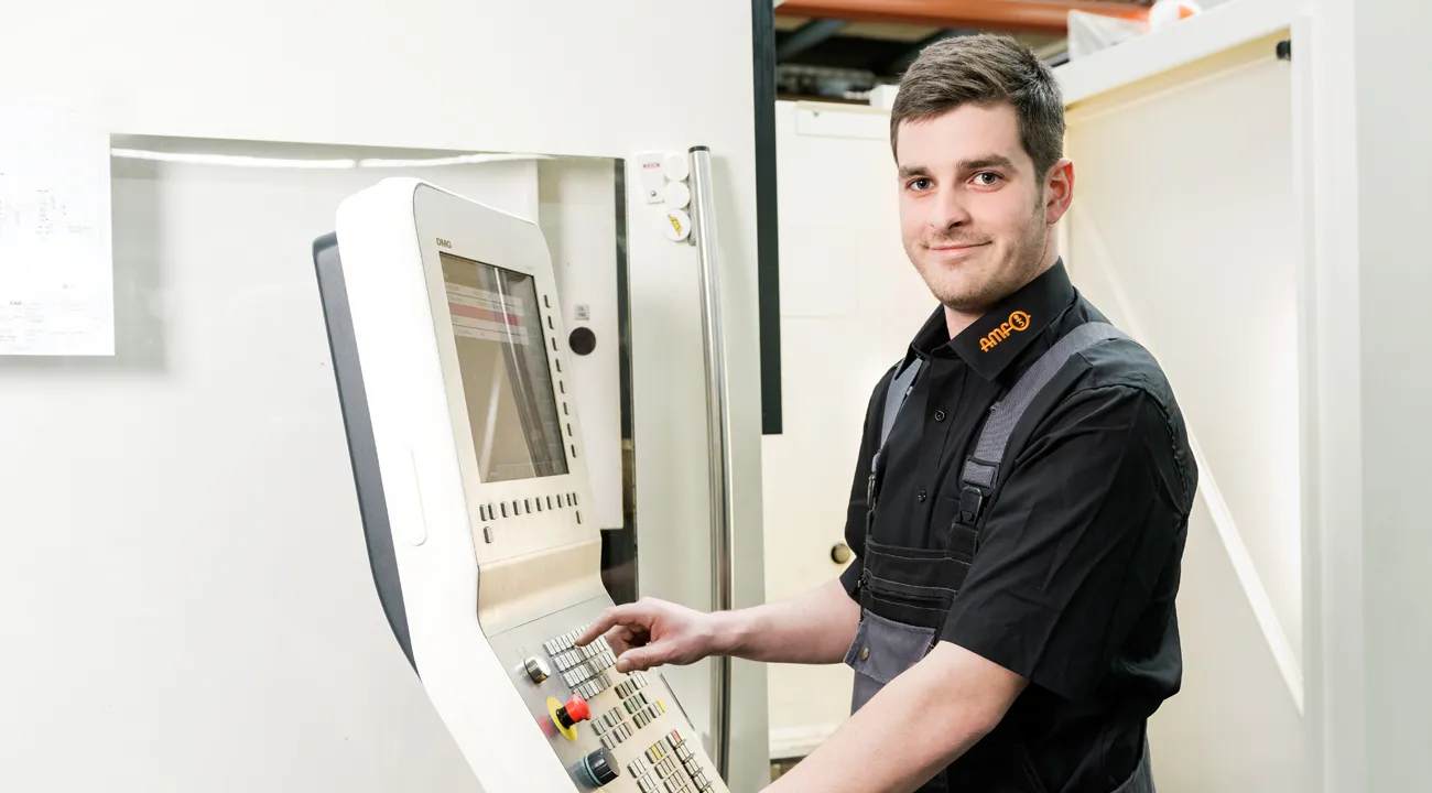AMF-Werkzeugmechaniker in Ausbildung an CNC-Steuerung.
